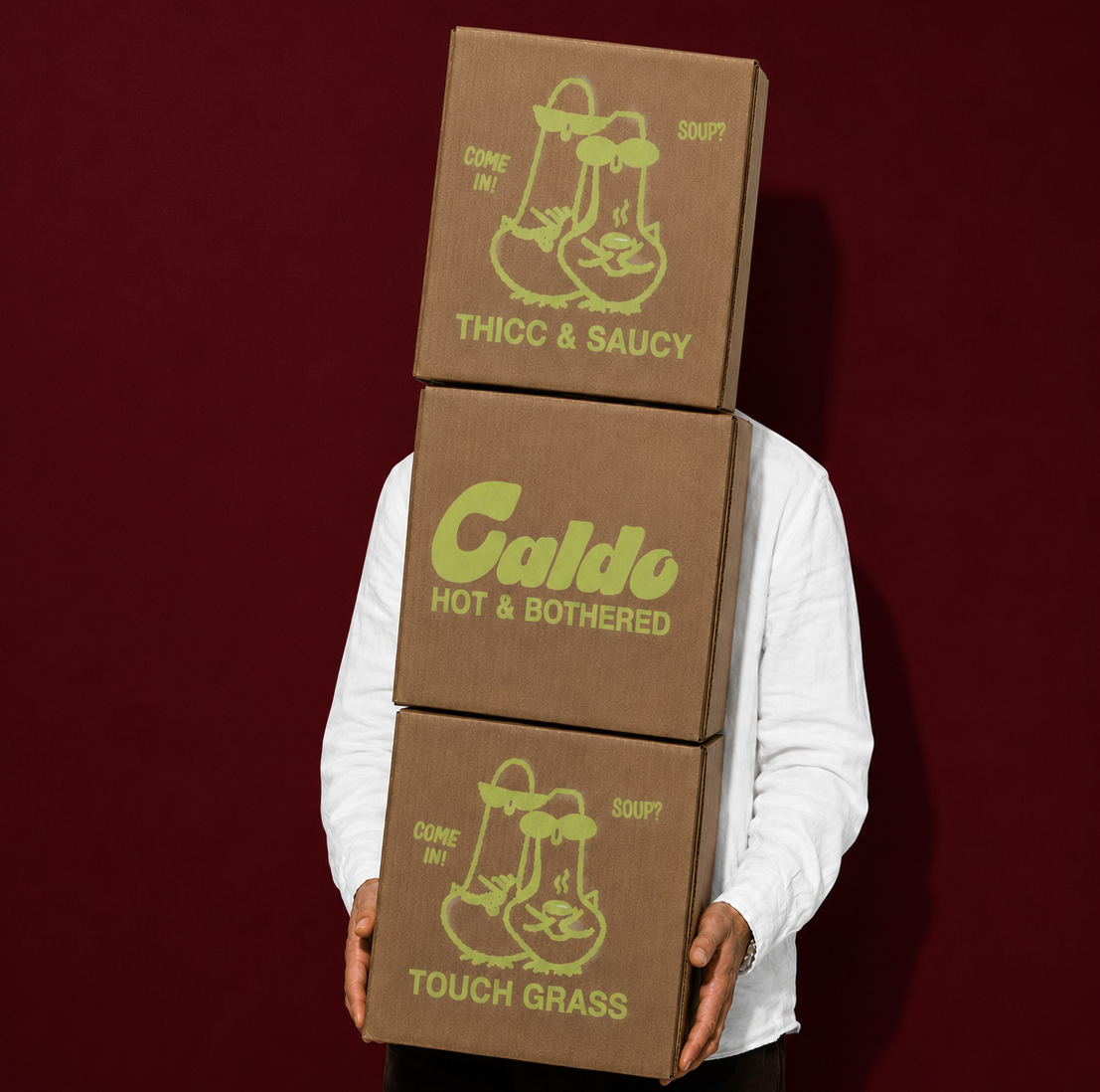 Person holding a stack of three Caldo soup boxes