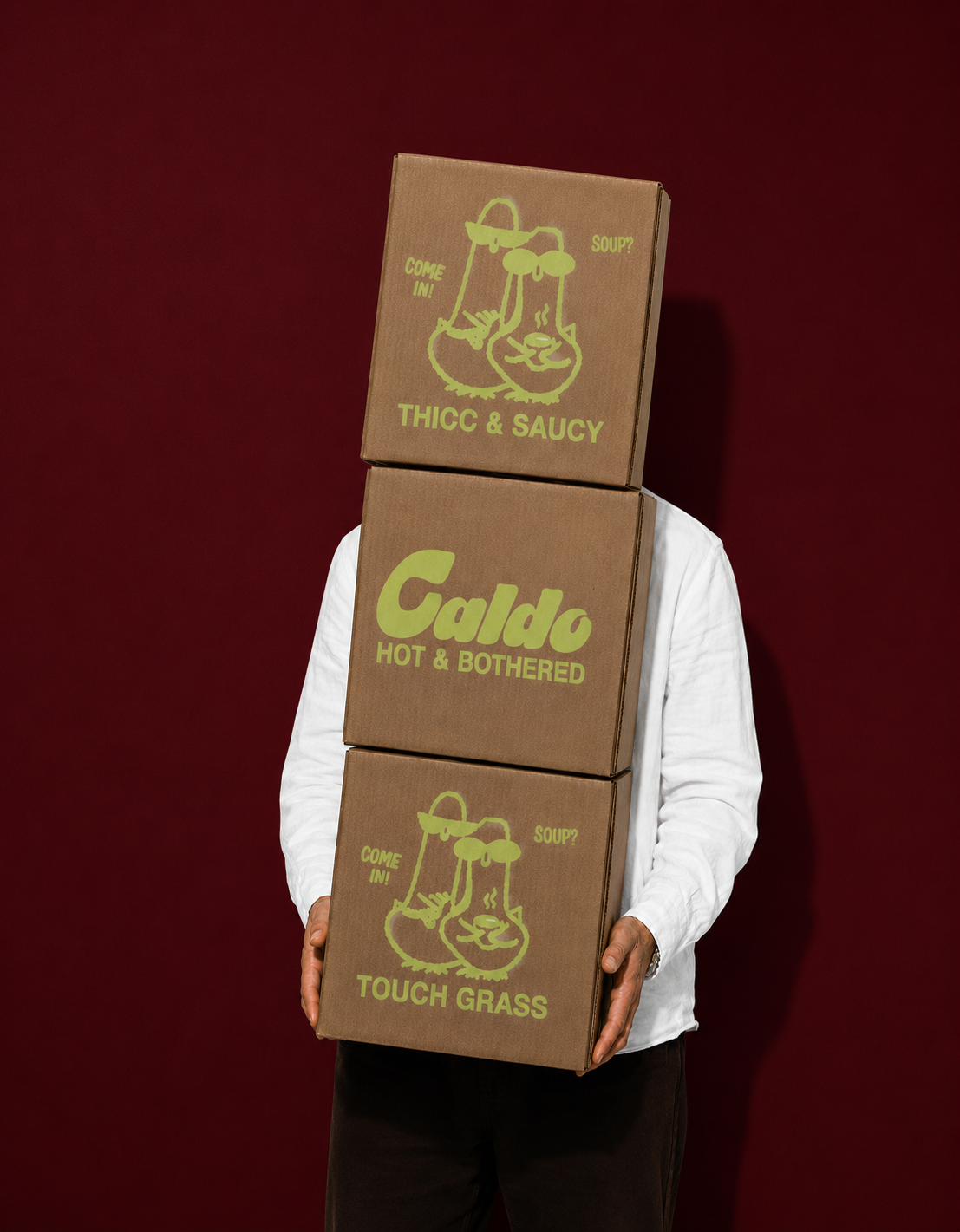 Person holding a stack of three Caldo soup boxes